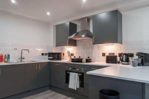 a kitchen with stainless steel appliances and gray cabinets at Lovely 1 Bedroom Apartment in Preston in Preston