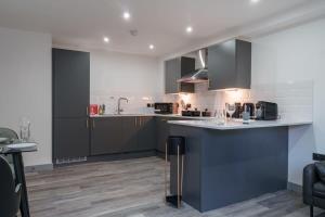 a kitchen with gray cabinets and a counter top at Lovely 1 Bedroom Apartment in Preston in Preston +9 photos