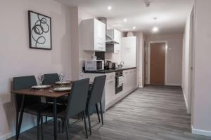 a kitchen and dining room with a table and chairs at Modern 2 Bed Apartment in Manchester - Sleeps 4 in Manchester