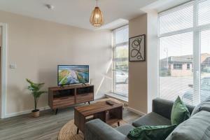ein Wohnzimmer mit einem Sofa und einem Flachbild-TV in der Unterkunft Lovely 1 Bedroom Manchester Apartment in Manchester