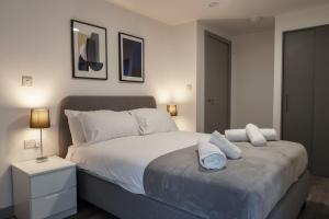 een slaapkamer met een bed met witte lakens en kussens bij Lovely 1 Bed Apartment in Liverpool Centre in Liverpool