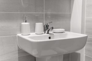 a white bathroom sink with two paper towels on it at Lovely 1 Bed Apartment in Liverpool Centre in Liverpool
