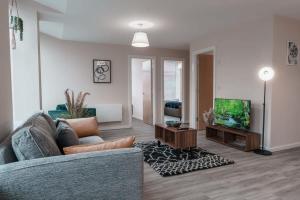 un soggiorno con divano e TV a schermo piatto di Contemporary 2 Bed Manchester Apartment - Sleeps 4 a Manchester