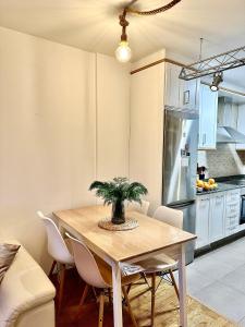 uma cozinha com uma mesa com cadeiras e um frigorífico em O Picho: apartamento céntrico. em Puentedeume