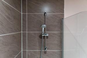 a shower with a glass door and a shower coil at Contemporary 2 Bed Manchester Apartment - Sleeps 4 in Manchester