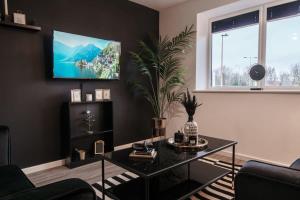 a living room with a table and a tv on a wall at Lovely 2 Bed Apartment in Manchester - Sleeps 4 in Manchester