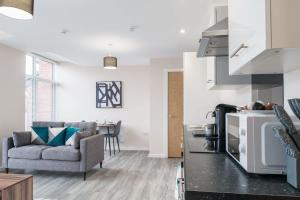 a kitchen and living room with a couch and a table at Fantastic 1 Bed Apartment Manchester - Sleeps 2 in Manchester