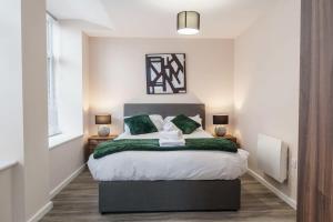 a bedroom with a large bed with a green blanket at Fantastic 1 Bed Apartment Manchester - Sleeps 2 in Manchester