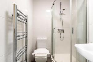 a bathroom with a shower and a toilet and a sink at Modern & Bright Budget Studio in Central Doncaster in Doncaster