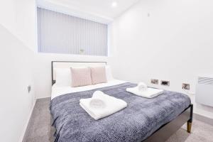 a white bedroom with a bed with two towels on it at Modern 1 Bed Apartment in Central Wolverhampton in Wolverhampton