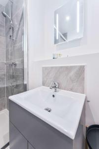 a white bathroom with a sink and a shower at Modern 1 Bed Apartment in Central Wolverhampton in Wolverhampton