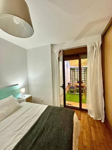 a bedroom with a bed and a sliding glass door at O Picho: apartamento céntrico. in Puentedeume