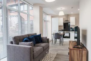 uma sala de estar com um sofá e uma mesa em Bright 1 Bed Apartment Manchester - Sleeps 2 em Manchester