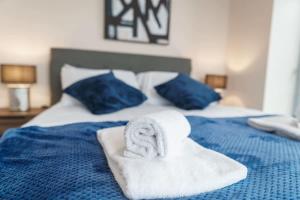 uma cama azul com toalhas por cima em Bright 1 Bed Apartment Manchester - Sleeps 2 em Manchester