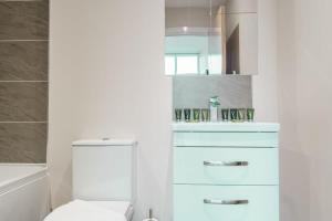 uma casa de banho com um WC branco e um lavatório. em Bright 1 Bed Apartment Manchester - Sleeps 2 em Manchester