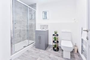 een witte badkamer met een toilet en een douche bij Contemporary 1 Bed Apartment in Central Wolverhampton in Wolverhampton