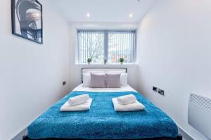 a bedroom with a large blue bed with two pillows at Contemporary 1 Bed Apartment in Central Wolverhampton in Wolverhampton