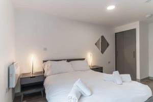 a bedroom with a large white bed with two night stands at Lovely 1 Bed Apartment in Central Liverpool in Liverpool