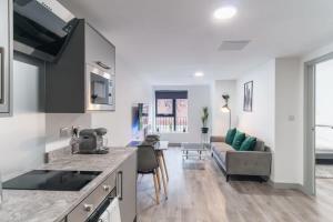 a kitchen and living room with a couch and a table at Lovely 1 Bed Apartment in Central Liverpool in Liverpool