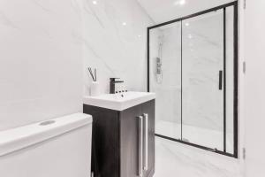 a white bathroom with a sink and a shower at Cosy 1 Bedroom Apartment in Burton-on-Trent in Burton upon Trent