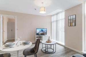 een witte woonkamer met een tafel en stoelen bij Modern 1 Bedroom Apartment Manchester - Sleeps 2 in Manchester