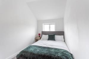 um quarto com uma cama com paredes brancas e uma janela em Modern 2 Bedroom Apartment in Central Bradford em Bradford