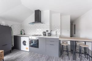 a kitchen with a stove and a washer and dryer at Modern 2 Bedroom Apartment in Central Bradford in Bradford