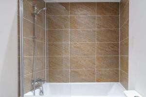 een badkamer met een douche en een wit bad bij Modern 1 Bedroom Apartment Manchester - Sleeps 2 in Manchester