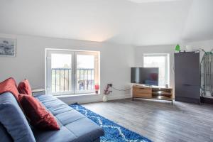 2 Bed Apartment Close to Bradford City Centre في برادفورد: غرفة معيشة مع أريكة زرقاء وتلفزيون