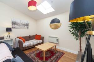 a living room with a couch and a table at Modern 2 Bed Attic Apartment in Brixton in London
