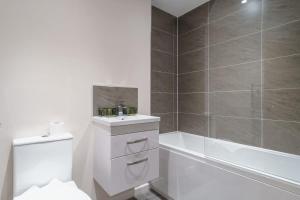 een badkamer met een toilet, een wastafel en een bad bij Bright 2 Bed Apartment Manchester - Sleeps 4 in Manchester