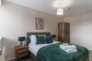 een slaapkamer met een bed met een groene deken bij Bright 2 Bed Apartment Manchester - Sleeps 4 in Manchester