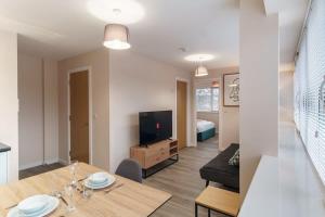 a living room with a dining table and a television at Fantastic 1 Bed Flat Manchester - Sleeps 3 in Manchester