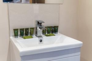 a bathroom sink with a faucet and green accents at Fantastic 1 Bed Flat Manchester - Sleeps 3 in Manchester