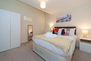 1 dormitorio con 1 cama grande y espejo en Characterful 2 Bedroom Apartment in Brixton, en Londres