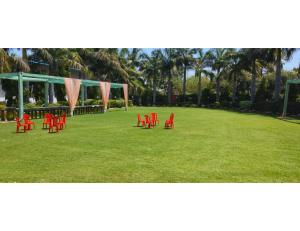 a group of red chairs sitting in a field at Hotel Shree Jee Bhawan, Sitapur in Sītāpur Mūāfi