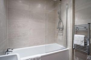 a bathroom with a shower with a tub and a sink at Modern Studio Apartment in Central Liverpool in Liverpool