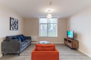 ein Wohnzimmer mit einem Sofa und einem TV in der Unterkunft Bright 2 Bed Apartment Manchester - Sleeps 4 in Manchester