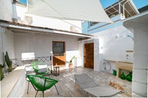 patio con sedie, tavolo e ombrellone di M’ami a San Cassiano