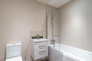 ein weißes Bad mit einem Waschbecken und einer Dusche in der Unterkunft Bright 2 Bed Apartment Manchester - Sleeps 4 in Manchester