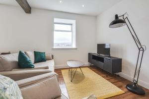 a living room with a couch and a television at Modern 2 Bedroom Apartment in Burnley in Burnley