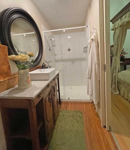 a bathroom with a sink and a shower with a mirror at Gold and Grapes Garden Suites in Rutherglen
