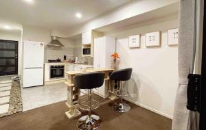 una cucina con bancone e due sgabelli di Waikato Uni guest room with private bathroom a Hamilton