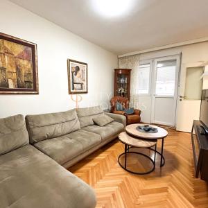 een woonkamer met een bank en een tafel bij Charming and lovely apartment in Podgorica Center in Podgorica