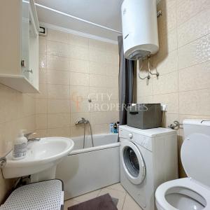 een badkamer met een wasmachine en een wastafel bij Charming and lovely apartment in Podgorica Center in Podgorica