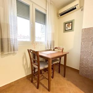 een eettafel met een stoel en een raam bij Charming and lovely apartment in Podgorica Center in Podgorica