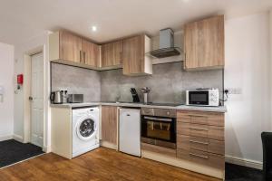 Modern Budget Studio in Central Doncaster في دونكاستير: مطبخ مع غسالة ملابس وميكرويف