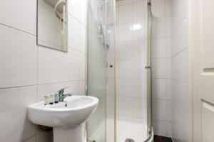 a white bathroom with a sink and a shower at Modern Budget Studio in Central Doncaster in Doncaster