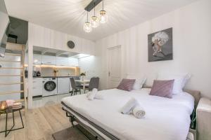sypialnia z dużym białym łóżkiem i kuchnią w obiekcie Superbe maison de ville avec jardin w mieście Montrouge