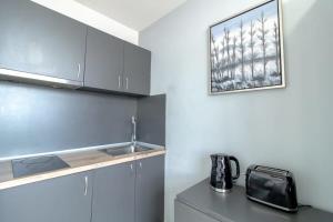 a kitchen with a sink and a microwave at Budget Sunderland Studio with Lovely Views in Sunderland